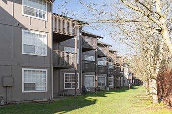 a row of apartment buildings with balconies and grass and trees at Capitol Crossing, Olympia, WA
